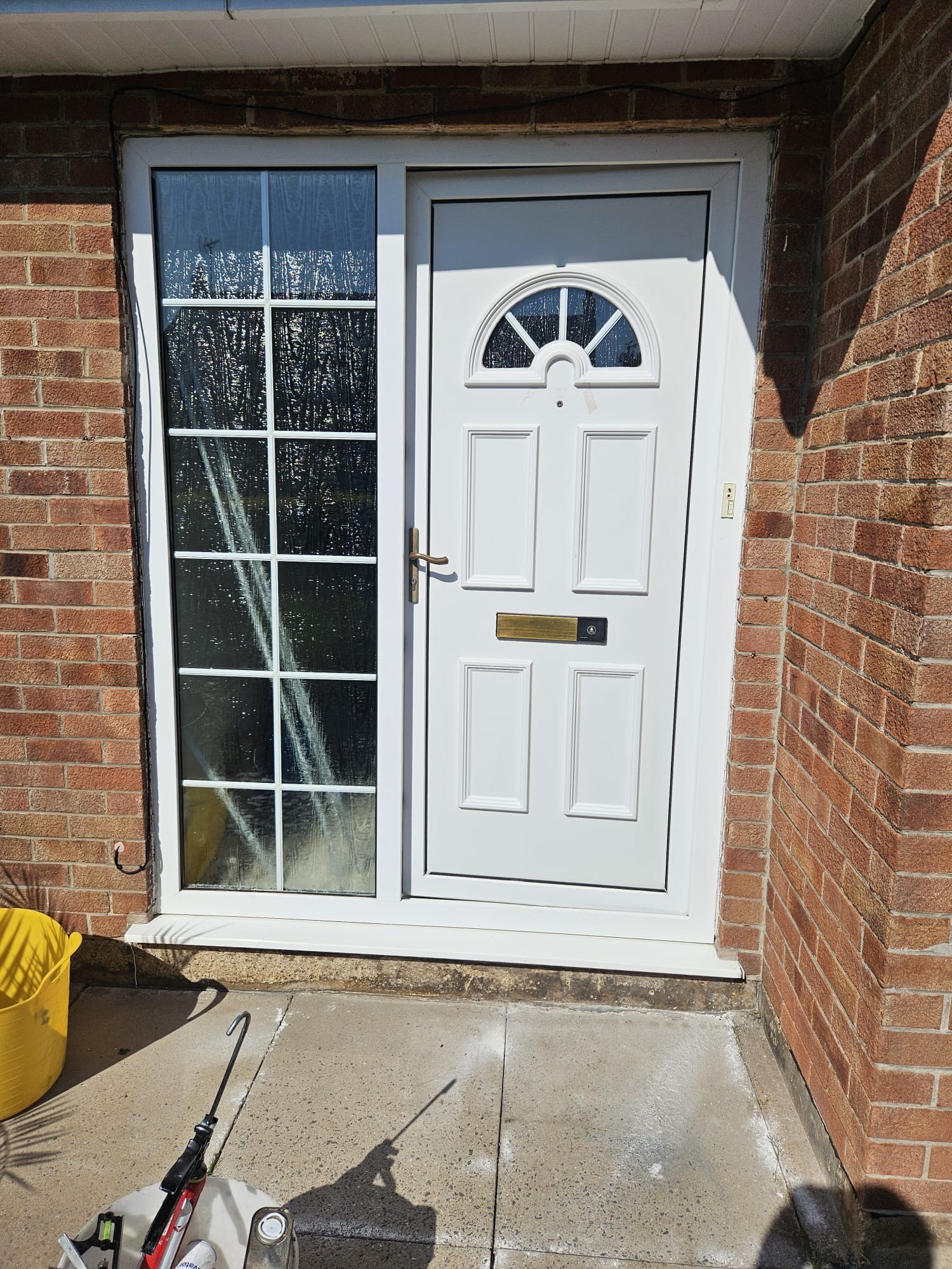 An old fashioned white front door and side window