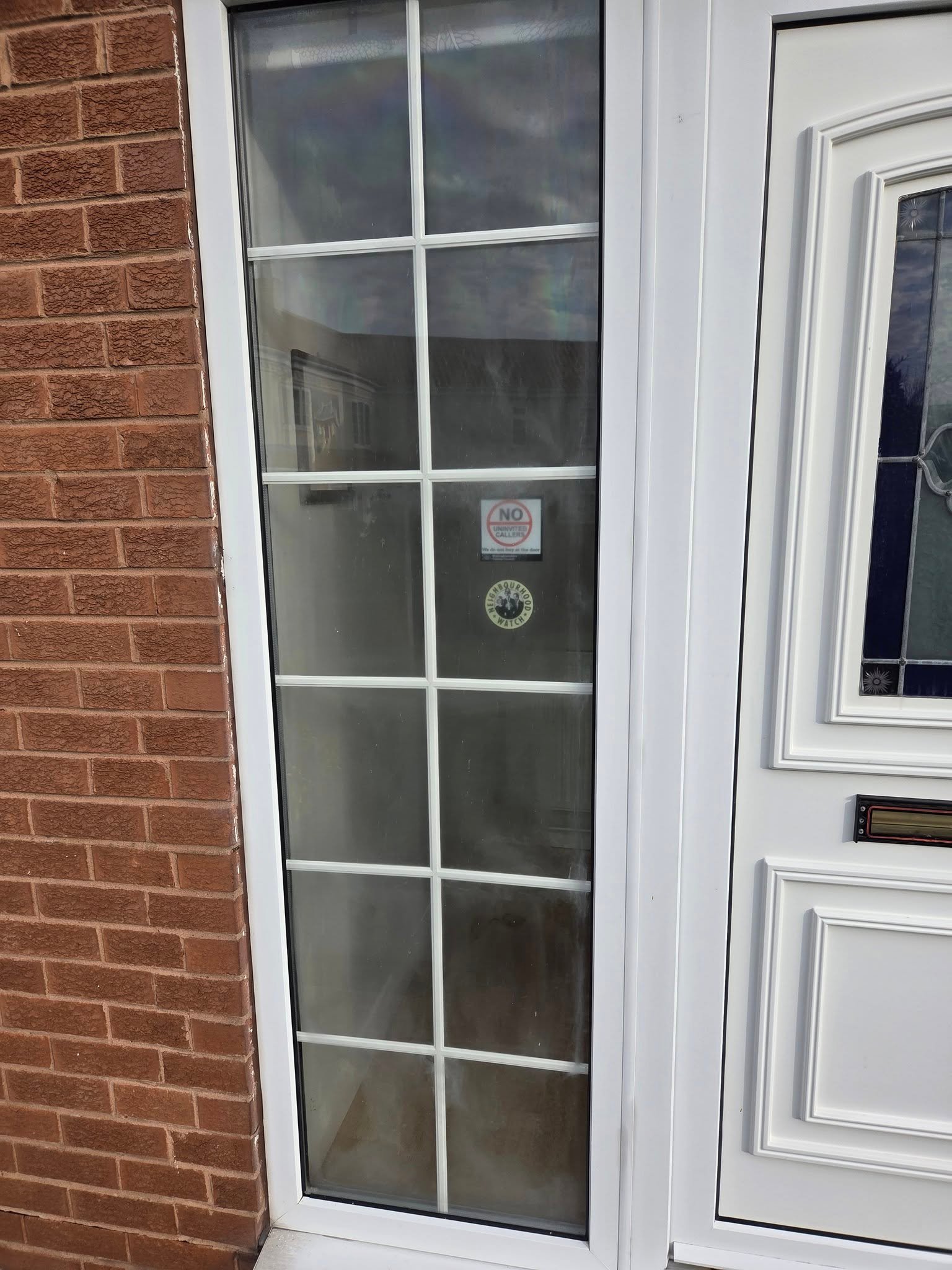 A tired looking window next to a front door